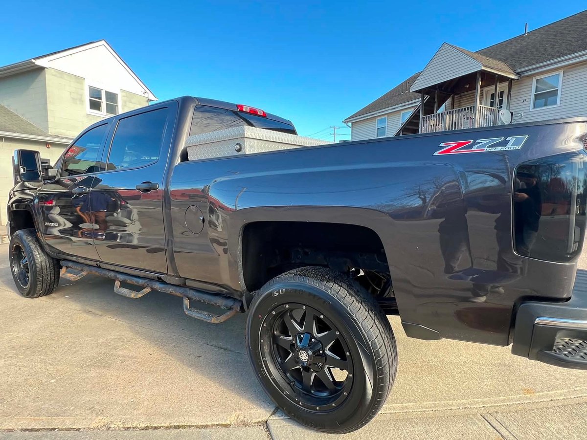 Dark gray pickup truck with a fresh detail, parked in a driveway