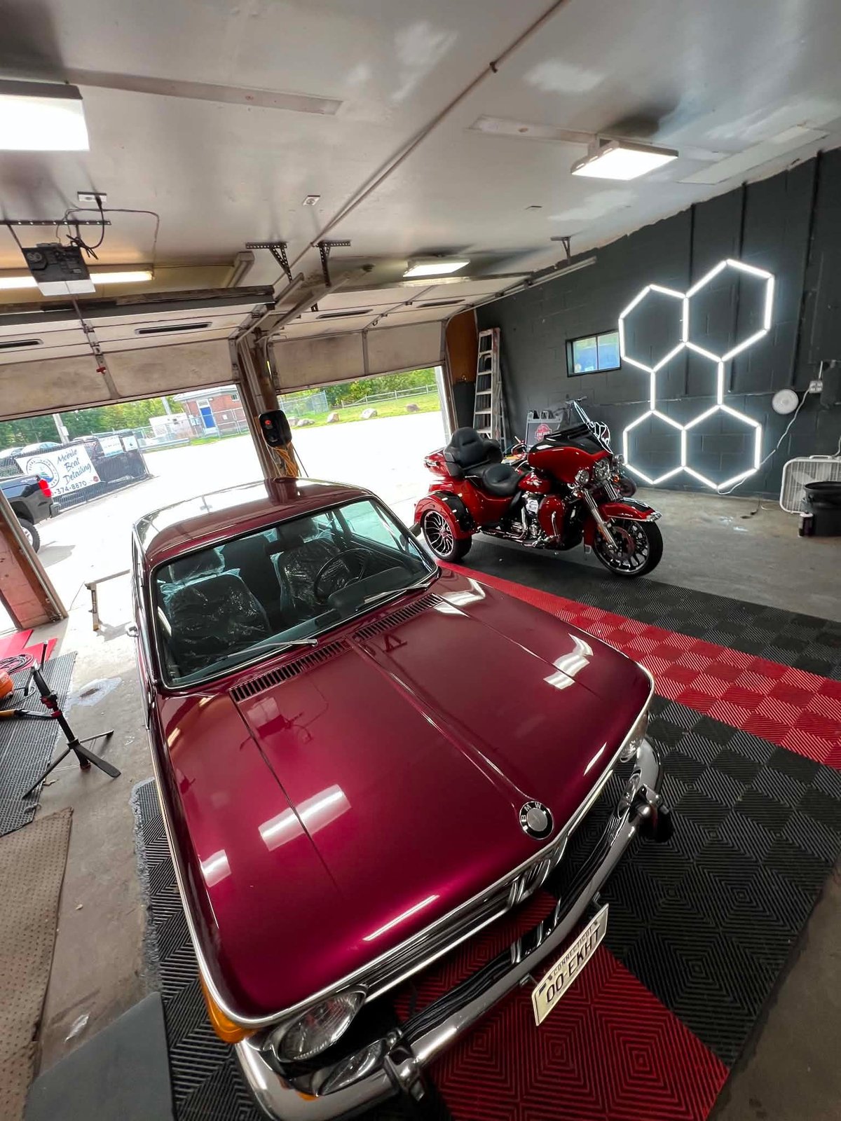 Classic BMW coupe and motorcycle finished with a deep, glossy shine in the shop