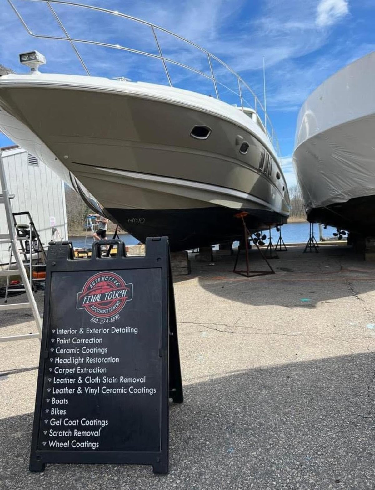 White boat on dry dock with The Final Touch detailing service sign